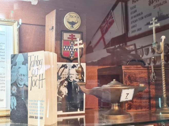 Toc H display cabinet with lamp, shield and a copy of Tubby on Toc H