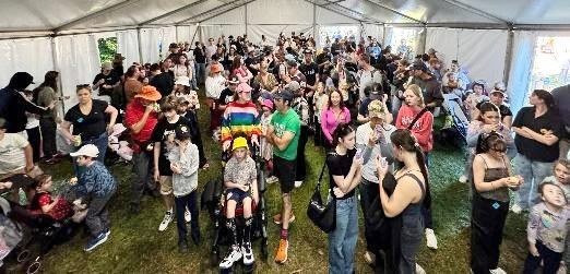 A large group of guests gathered under a marquee at the Ekka