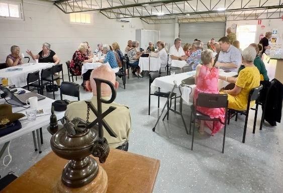 Members gathered in the hall with the Toc H lamp in the foreground