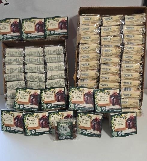 Boxes of individual Christmas puddings stacked ready for donation