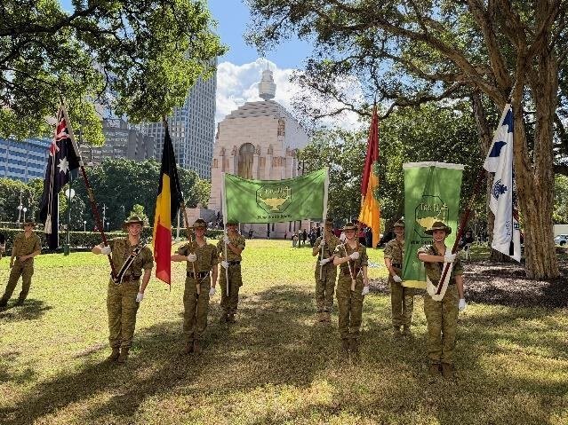 Cadets on duty beside flags at an Anzac Day service